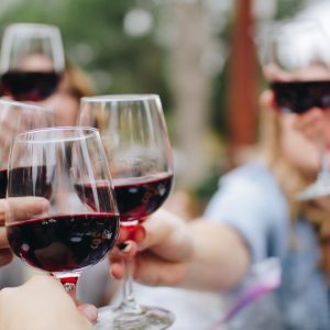 people clinking glasses of red wine