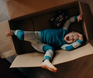 little boy crying in a cardboard box