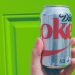 person holding a diet coke can against a bright green background