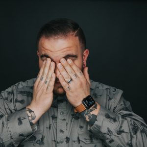man rubbing his eyes