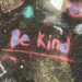 Be Kind written in sidewalk chalk on the ground
