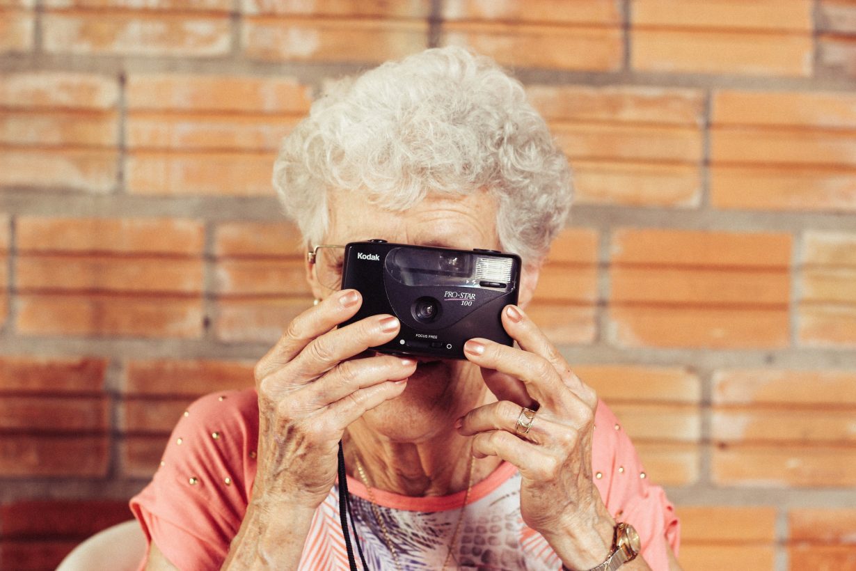 old woman holding a camera up to her face