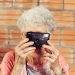old woman holding a camera up to her face
