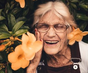 old woman smiling in flowers