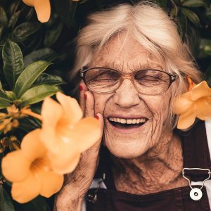 old woman smiling in flowers
