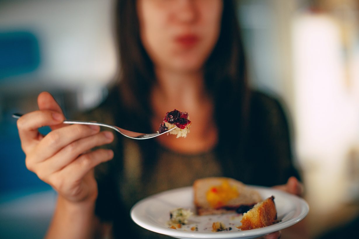 close up of a plate of food with woman in background