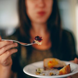 close up of a plate of food with woman in background