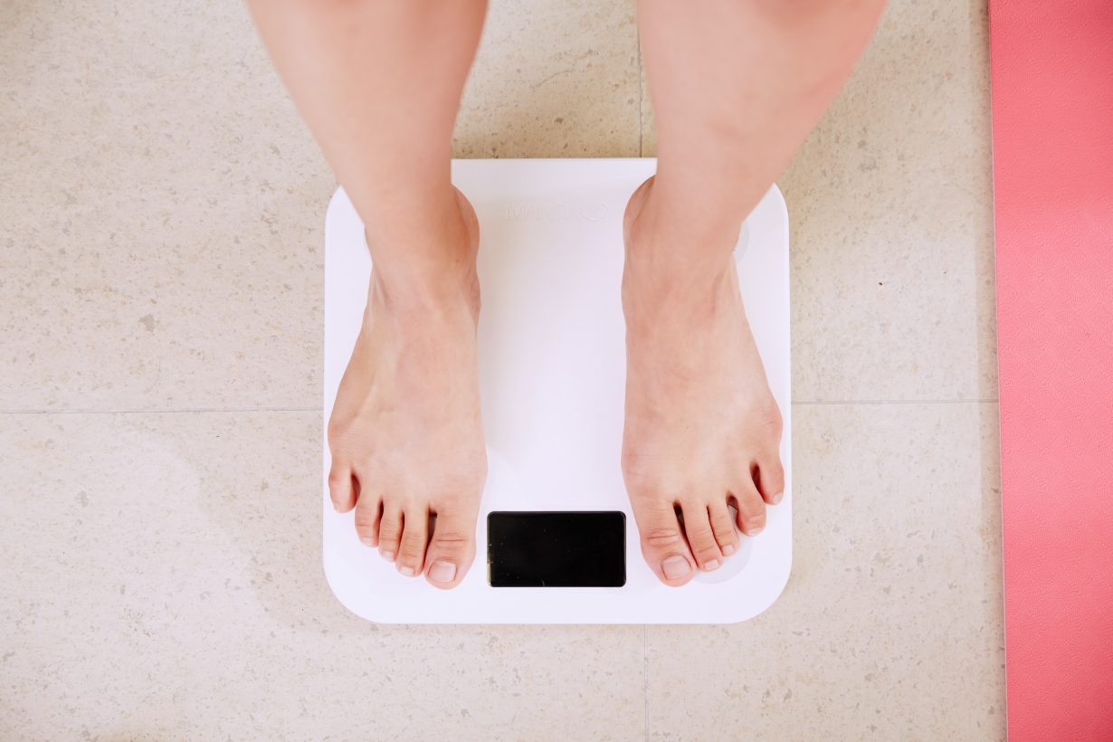 person standing on a white weight scale