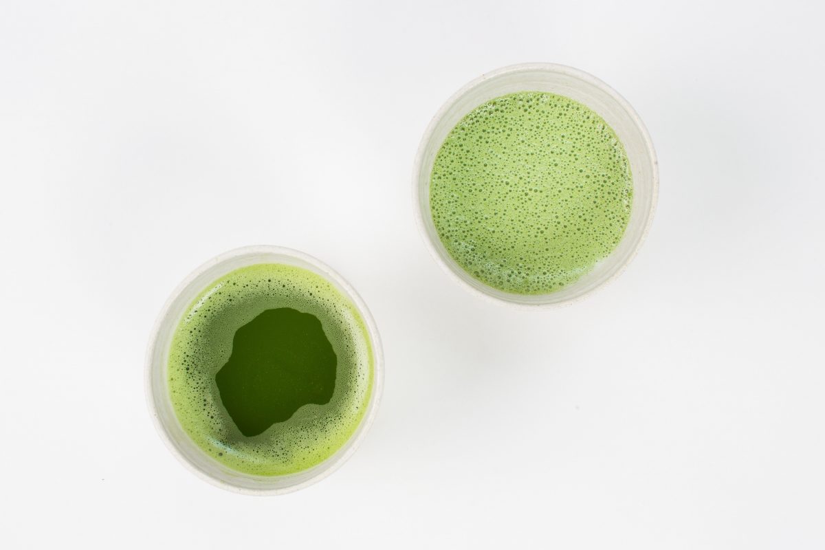 two cups of green tea on a white surface