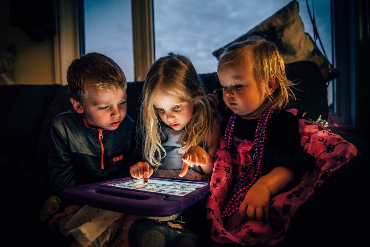 children looking at the screen of a tablet