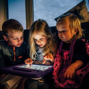 children looking at the screen of a tablet