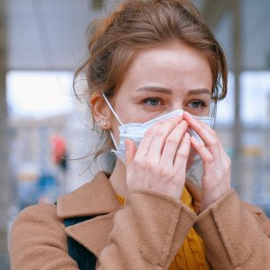 woman wearing mouth guard and touching her face