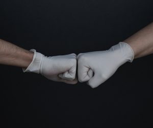 gloved hands giving a fist bump