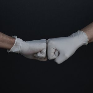 gloved hands giving a fist bump