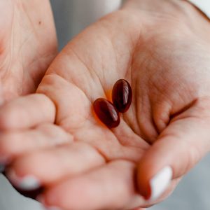 hands holding two red pills