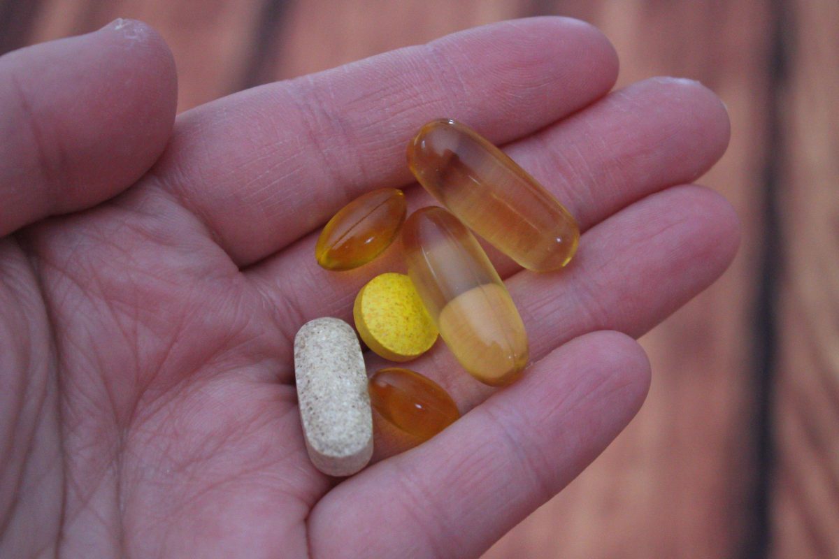 person holding vitamins and supplements in their hands