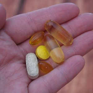 person holding vitamins and supplements in their hands