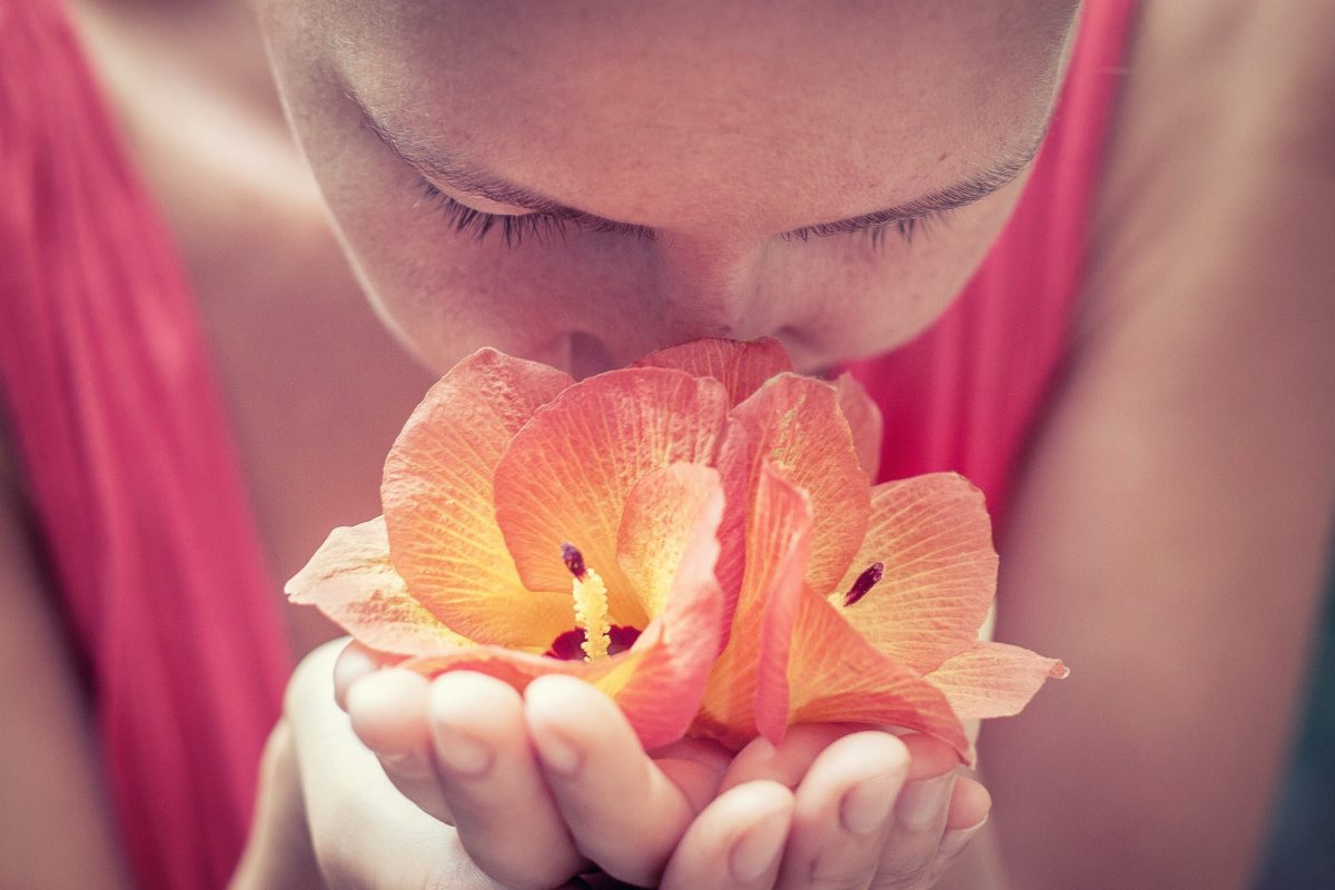 woman holding flowers up to her nose
