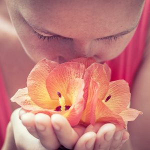 woman holding flowers up to her nose