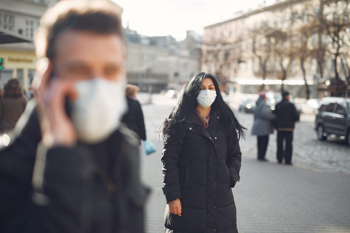person wearing face mask walking on a street