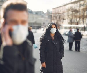 person wearing face mask walking on a street