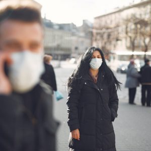 person wearing face mask walking on a street