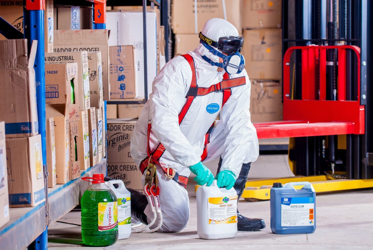 man in white suit working with chemicals