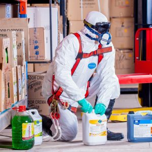 man in white suit working with chemicals