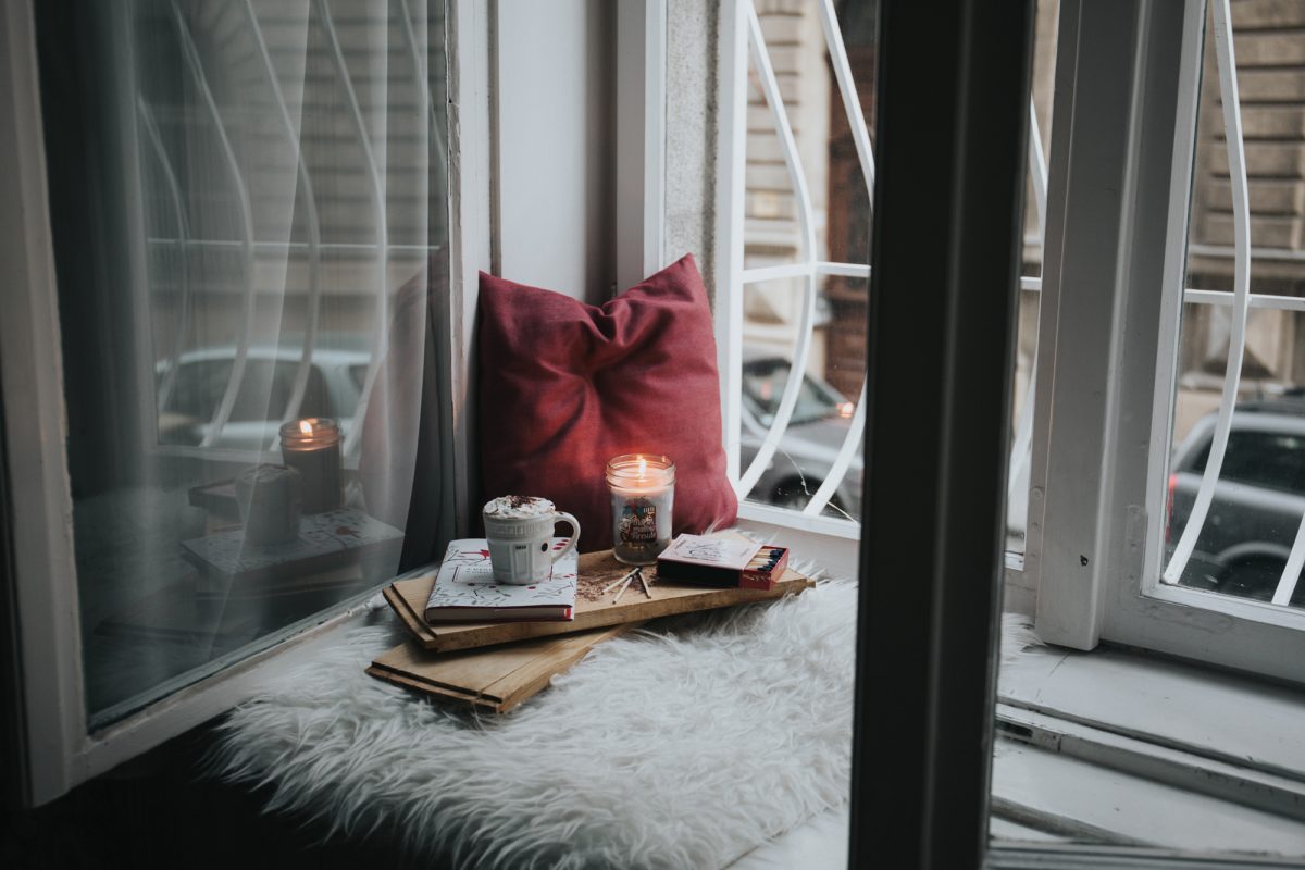 window seat with books and coffee and a candle