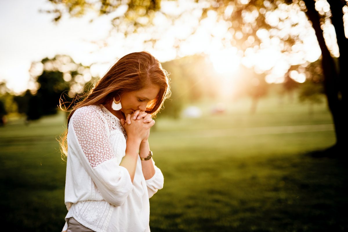 woman praying in a field
