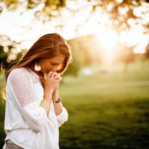 woman praying in a field