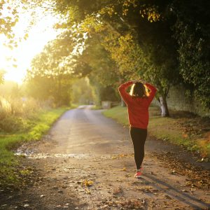 woman walking on a road lined with trees