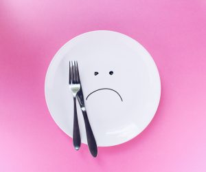 sad face flat lay plate on pink background