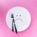 sad face flat lay plate on pink background