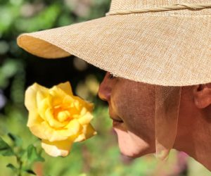 woman sniffing yellow flower