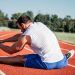 man stretching on a runners track