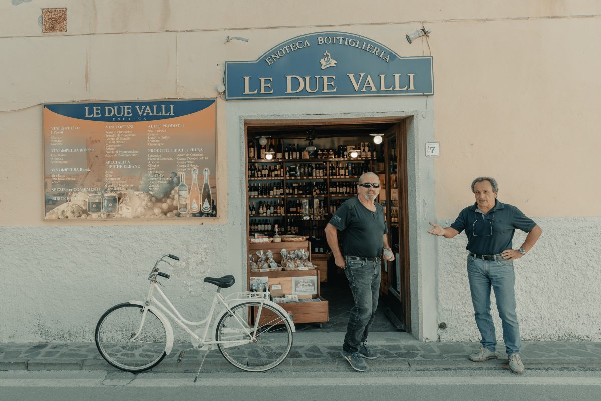 two italian men standing in front of a store