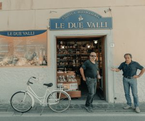 two italian men standing in front of a store