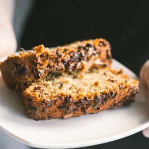 woman holding plate with banana bread slices on it