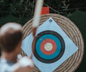 man shooting an arrow at a bullseye target
