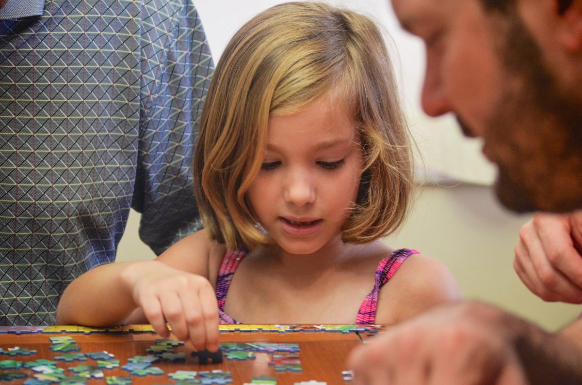 little girl working on a jigsaw puzzle
