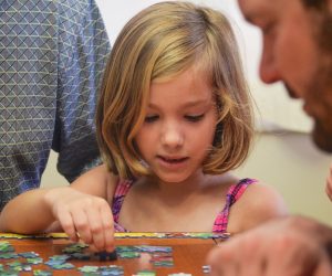 little girl working on a jigsaw puzzle