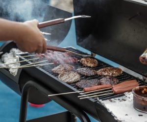 person cooking food items on a barbecue grill