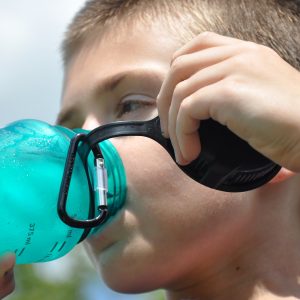 child drinking from a plastic bottle