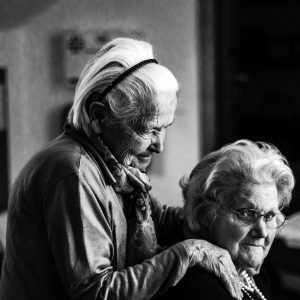 two old women standing near each other looking at the camera
