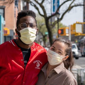 two people smiling with face masks on