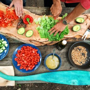 two people chopping a bunch of vegetables