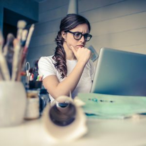 woman looking stressed while working at her computer