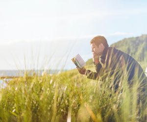man reading along on a bench
