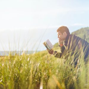 man reading along on a bench